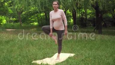 <strong>孕妇</strong>在公园里<strong>做瑜伽</strong>的地毯上，站在一条腿上的姿势，体式，树式。